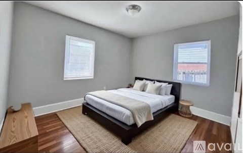A bedroom with a bed, a window, and a rug.