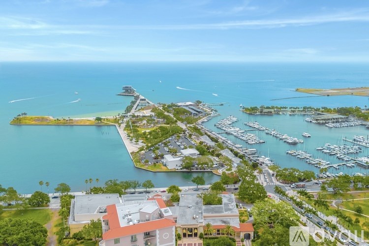 A marina with boats and yachts is surrounded by buildings.