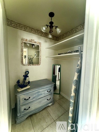A blue chest of drawers with a mirror and an anchor on top.