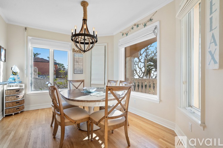 A dining room with a table and chairs and a chandelier.