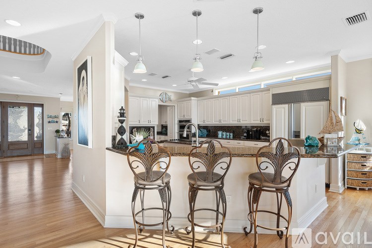 A kitchen with a bar and two chairs.