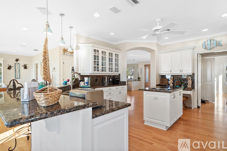 A kitchen with white cabinets and a black countertop.