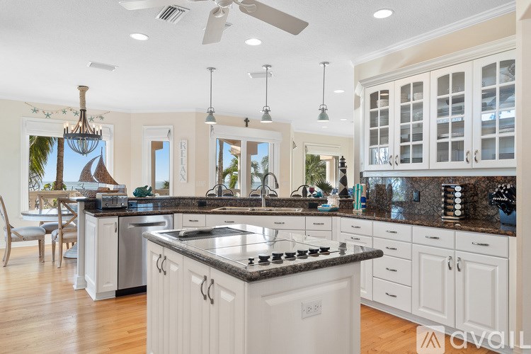 A kitchen with a black granite countertop and white cabinets.