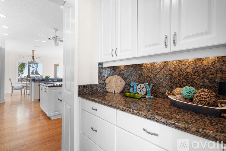 A kitchen with white cabinets and a granite countertop.