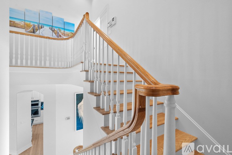 A staircase with a wooden handrail and white balusters.