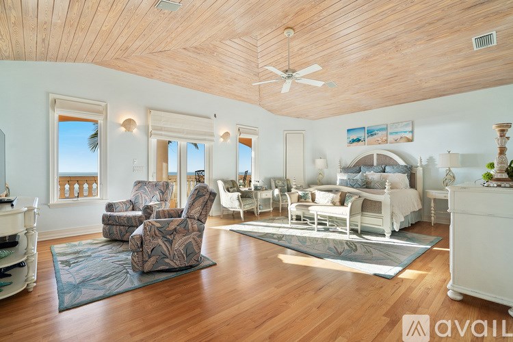 A spacious bedroom with a large bed and a wooden ceiling.