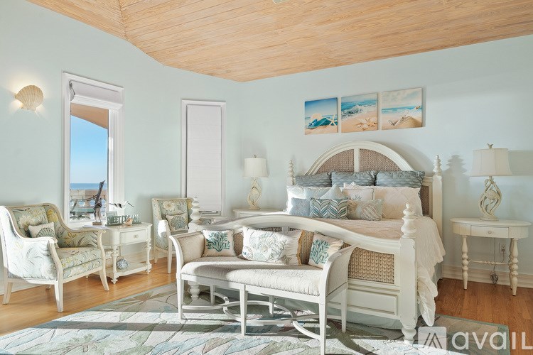 A bedroom with a large bed, a chair, and a table.