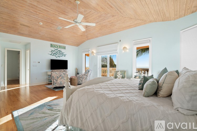 A bedroom with a large bed and a ceiling fan.
