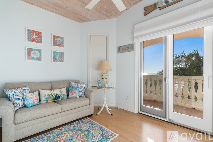 A living room with a couch, a table, and pictures on the wall.