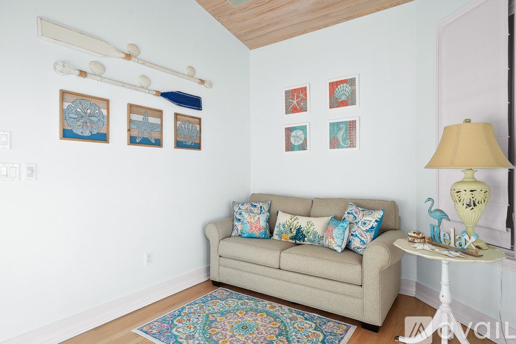 A living room with a couch, a table, and pictures on the wall.