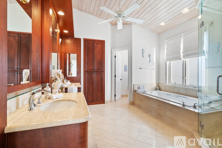 A bathroom with a marble countertop and a ceiling fan.