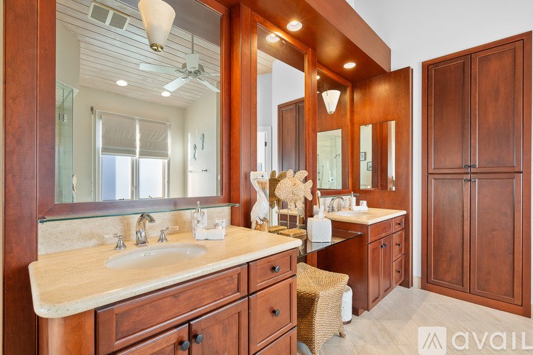 A bathroom with a vanity, a mirror, and a cabinet.