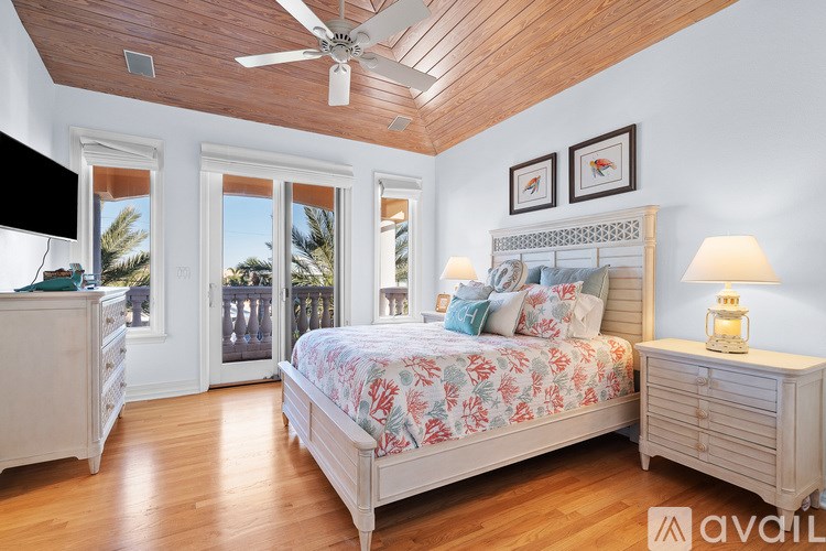 A bedroom with a large bed, a dresser, and a ceiling fan.