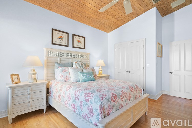 A bedroom with a large bed and a wooden ceiling.