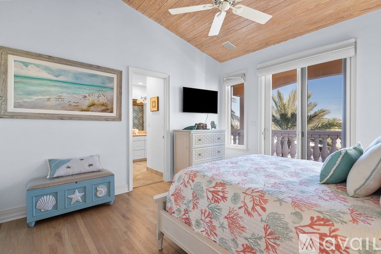 A bedroom with a bed, a bench, and a painting on the wall.