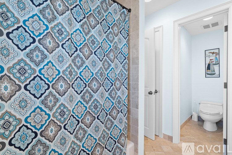 A bathroom with a patterned shower curtain and a white toilet.