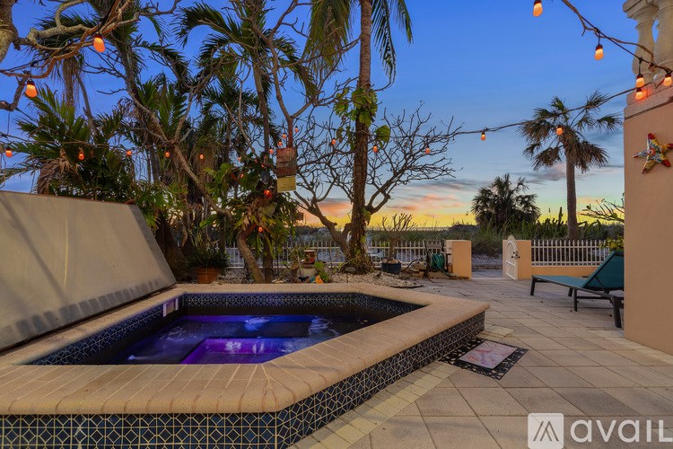 A pool surrounded by palm trees and string lights.