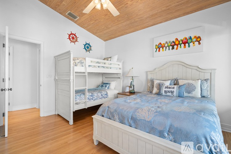 A bedroom with a blue bedspread and a white bed.
