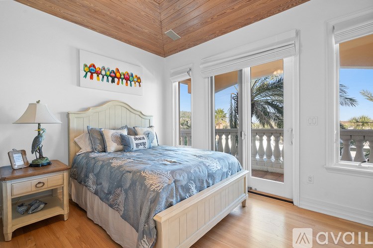 A bedroom with a large bed and a wooden floor.