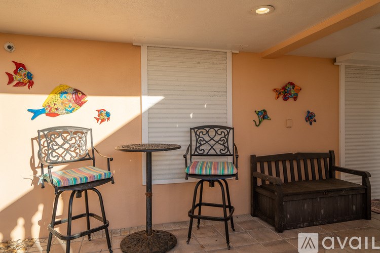 A patio with a chair, table, and bench.