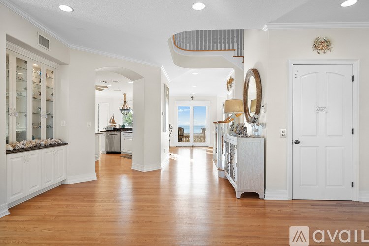 A spacious, well-lit room with wooden floors and white walls.