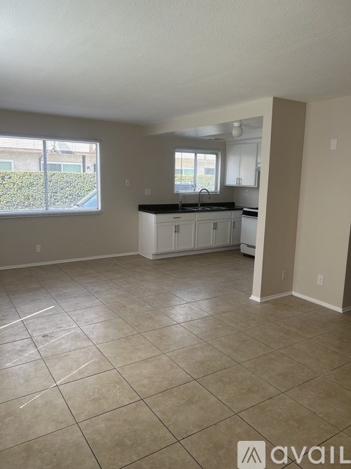 A kitchen area with tile flooring and a countertop.