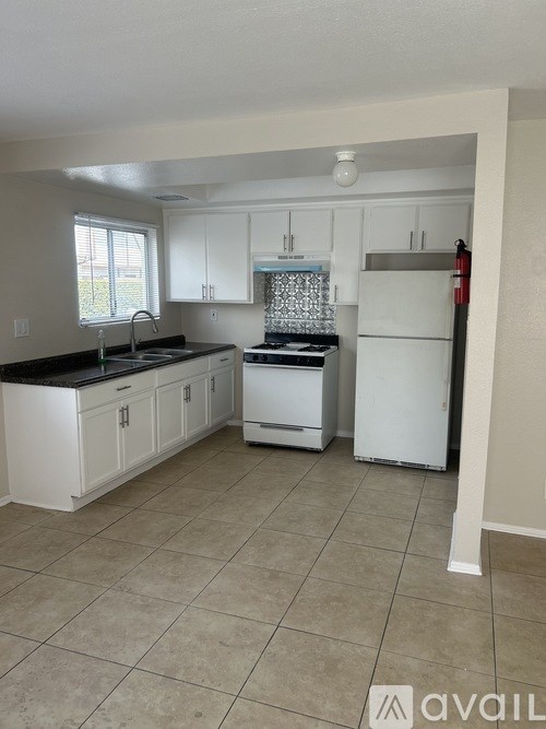 A kitchen with white cabinets and appliances.
