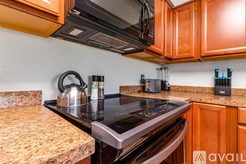 A kitchen with wooden cabinets and a black stove top.