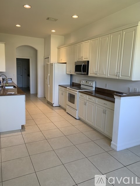 A kitchen with white cabinets and appliances.
