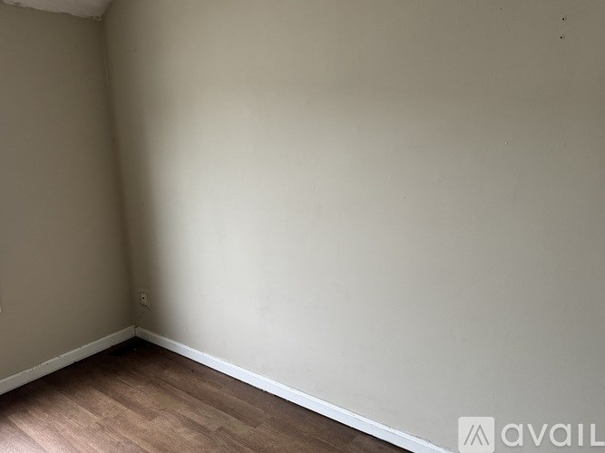 A room with wooden flooring and white walls.