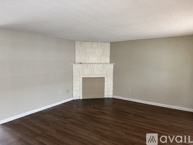 A room with a fireplace and wooden floors.