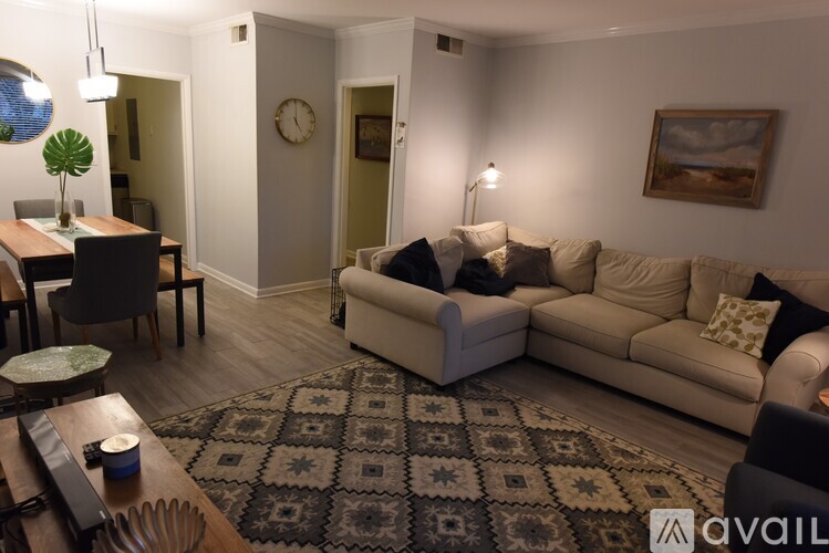 A living room with a beige couch and a patterned rug.