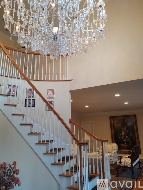 A chandelier hangs over a staircase in a home.