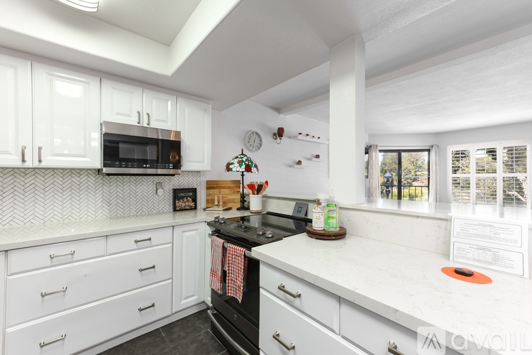 A kitchen with white cabinets and a black stove top.