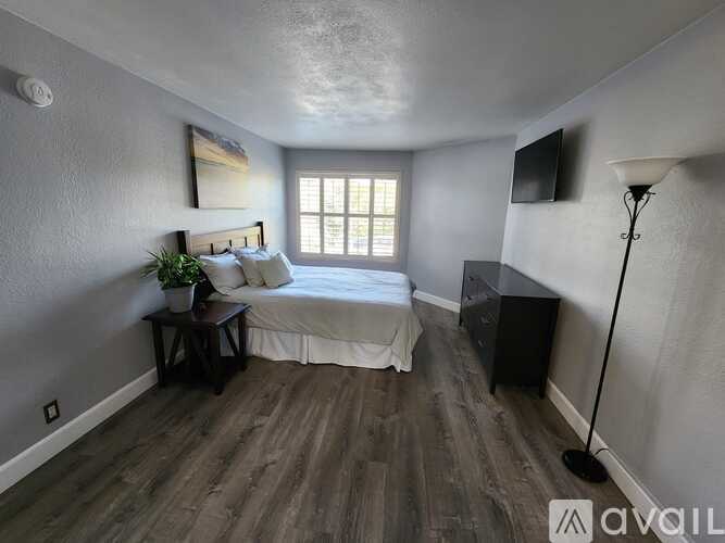 A bedroom with a bed, nightstand, and lamp.
