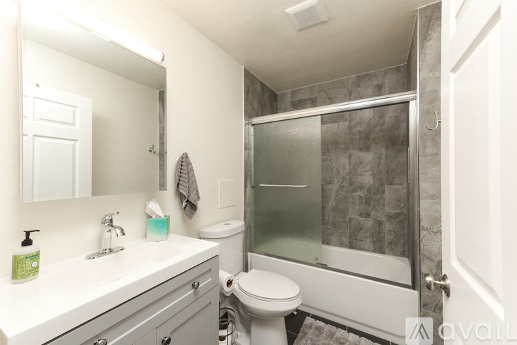 A bathroom with a toilet, sink, and shower.