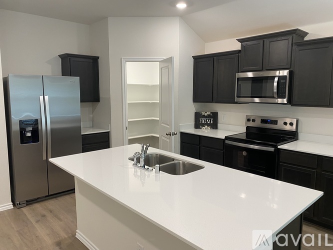 A kitchen with a white countertop and black cabinets.