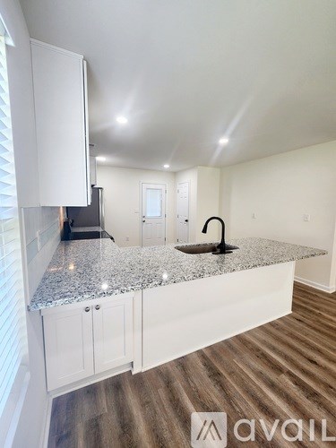 A kitchen with white cabinets and a granite countertop.