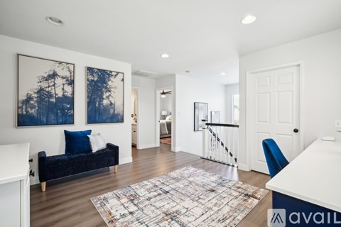 A living room with a blue couch and a white dining table.