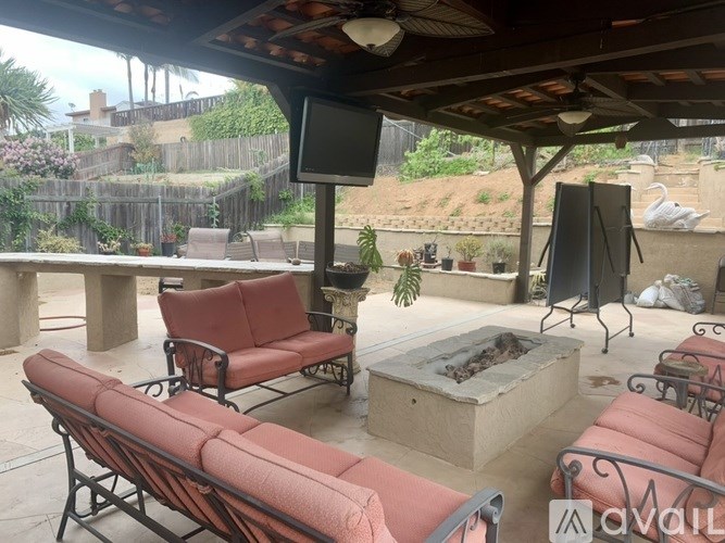 A patio with red couches and a fire pit.
