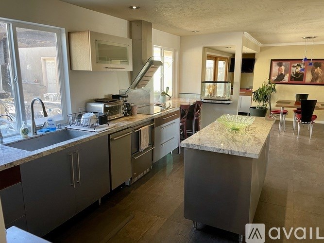 A kitchen with a sink, stove, and countertop.
