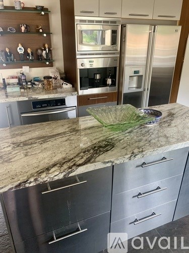 A kitchen with granite countertops and stainless steel appliances.