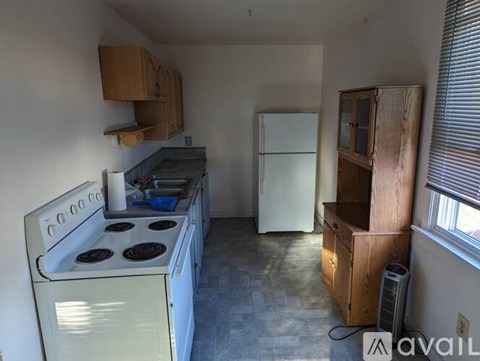 A kitchen with a white stove and a white refrigerator.