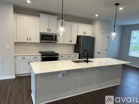 A kitchen with white cabinets and a large island.