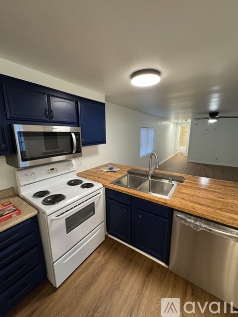 A kitchen with a white stove and blue cabinets.