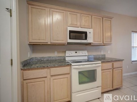 A kitchen with wooden cabinets and a granite countertop.