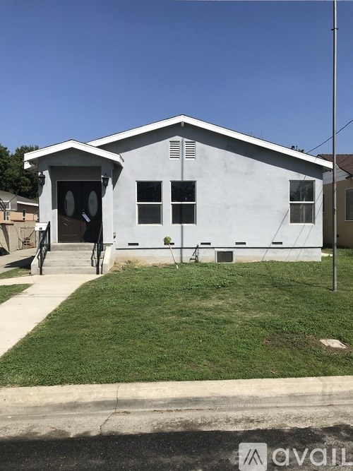 A white house with a brown door and windows.