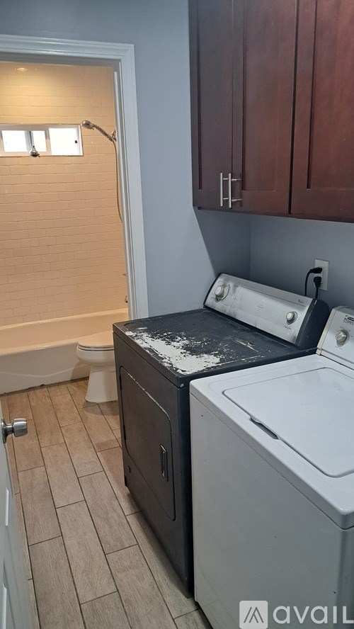 A dirty kitchen with a washing machine and a toilet.