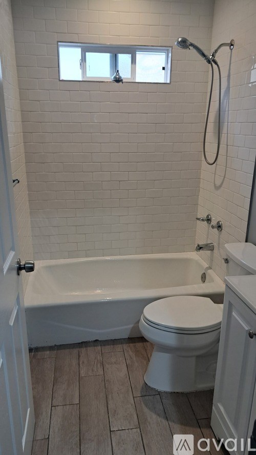 A white toilet sits next to a bathtub in a bathroom.