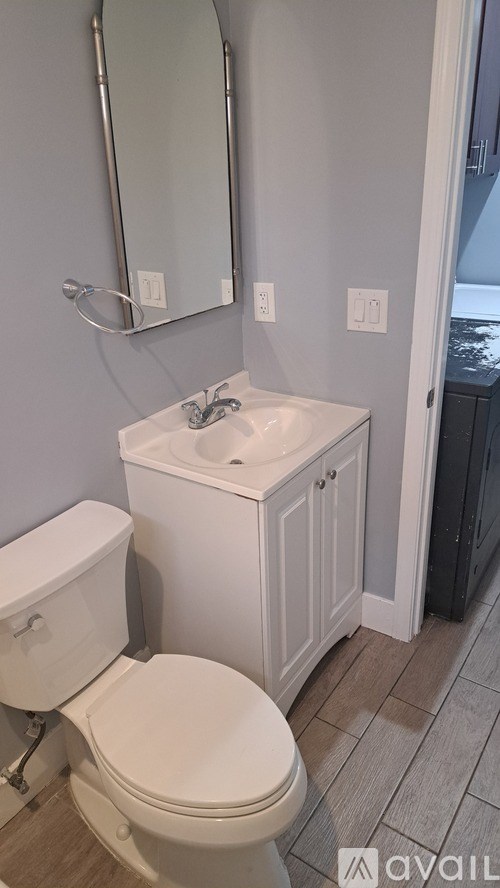 A white toilet and sink in a bathroom.